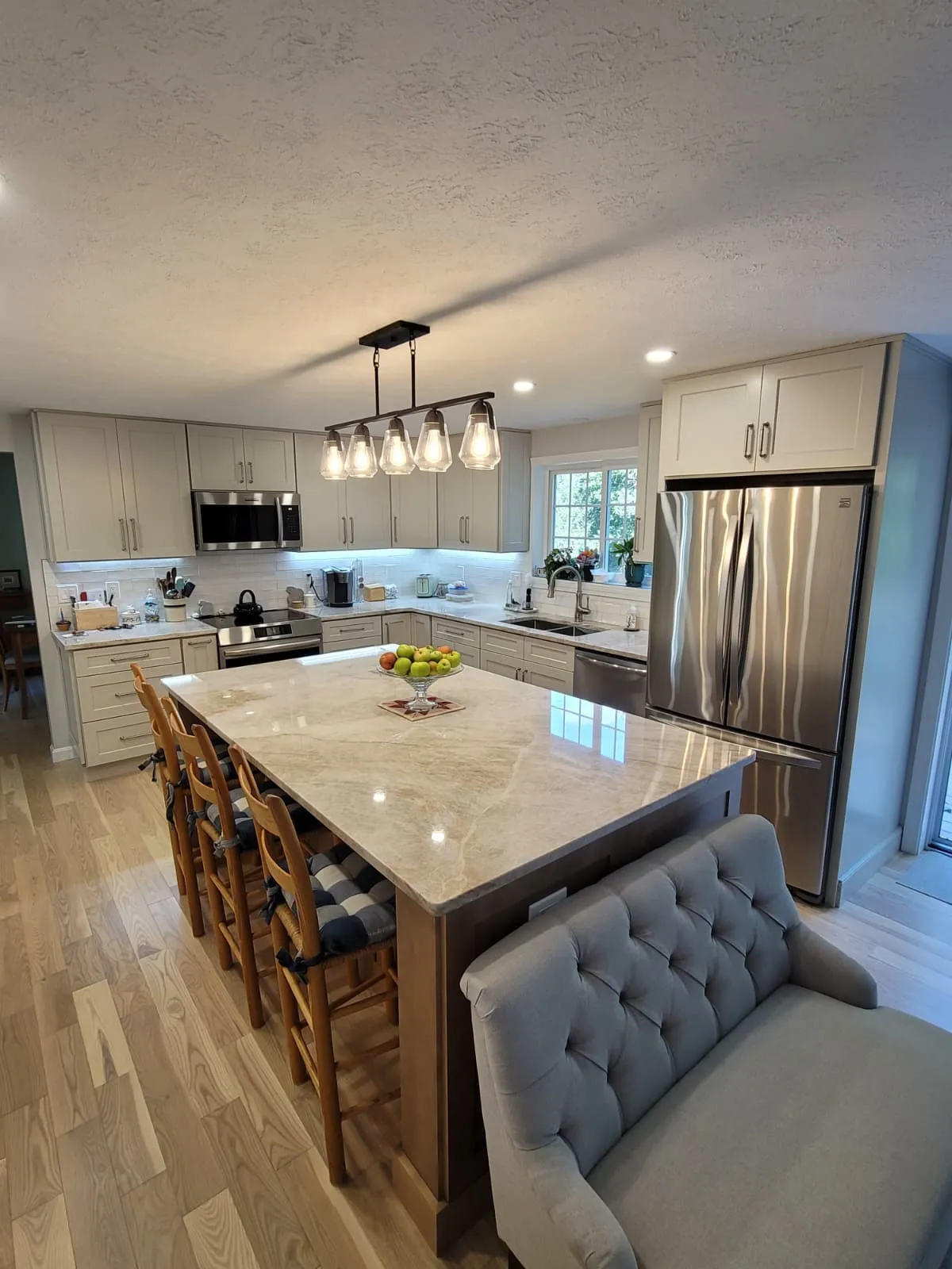 Pendant lighting over a marble kitchen island, installed by Storm Electrical