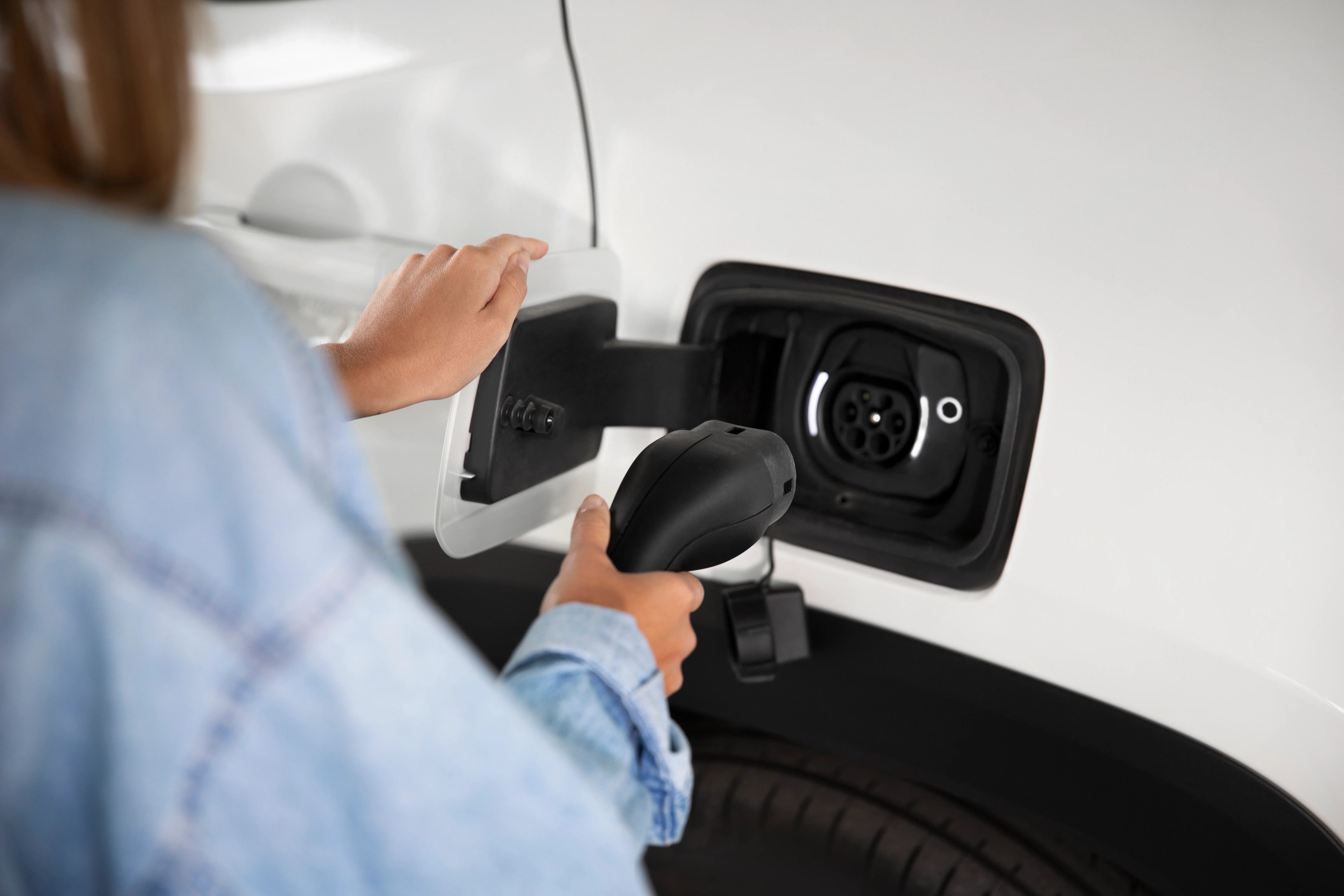 Plugging a charging cable into an electric car